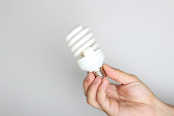 energy saving light bulb in hand on a light background