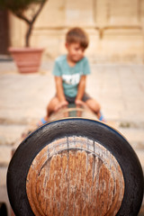4 years old boy sitting on the medieval canon in Mdina Malta