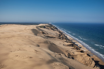 Panorama view of the danish sand cliff and dunes with blue ocean and bright summer sun light. Rubjerg Knude Lighthouse, Lønstrup in North Jutland in Denmark, Skagerrak, North Sea