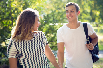 Obraz premium Young couple are walking in the park on a sunny day