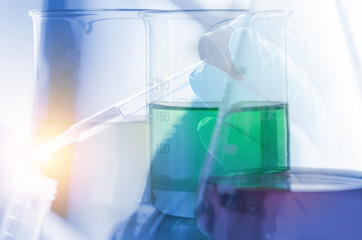 A pipette dropping sample into a test tube,abstract science background