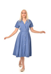 full length portrait of blonde girl wearing blue dress. standing pose. isolated on white  studio background.