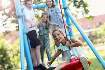 Fototapeta na wymiar Joyful family having fun on playground