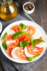 Close-up photo of caprese salad with ripe tomatoes, basil, buffalo mozzarella cheese. Italian and Mediterranean food concept. Fresh and healthy organic meal. Starter and antipasti. 