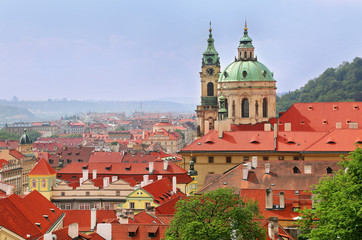 Fototapeta premium St Nicholas Church dome above red roof tops of Mala Strana, Prague, Czech Republic