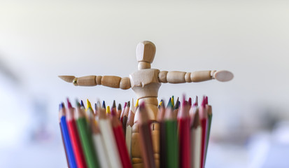 Wood mannequin figure with colorful pencils. Concept of art supplies, creativity and education - Powered by Adobe