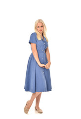 full length portrait of blonde girl wearing blue dress. standing pose. isolated on white  studio background.