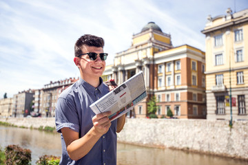 Man reading newspaper at city