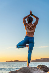 Woman doing yoga on the beach
