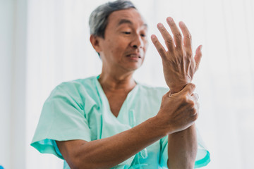 pain and wrist pain  senior asian grandfather in patient uniform suffer from body problem  health...