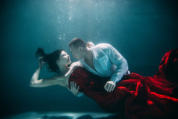 Fototapeta na wymiar Couple swimming underwater