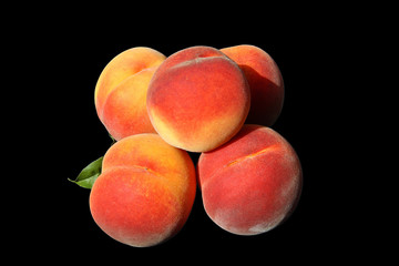 Peaches are large mature beautiful. Isolated black background.