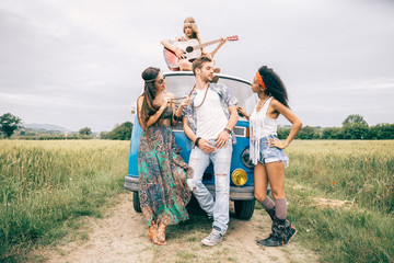 Happy friends driving a vintage minivan