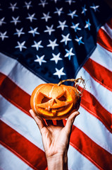 pumpkin halloween in hand against the background of the American flag