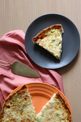 Quiche lorraine with ham, cheeese, broccoli and leek. One cut slice. Top view. 
