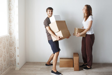 Young married couple among cardboard boxes.