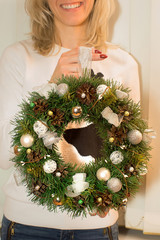 Close up of female holding beautiful handmade Christmas wreath