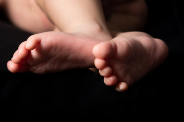 newborn baby feet isolated on black background