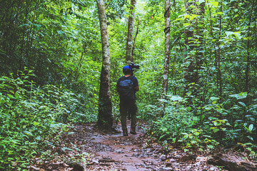 Photographer asian man Traveling photograph Nature. travel relax in the holiday walk in the forest.