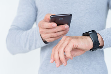 modern technology and helpful applications and devices. mobile phone and smart watch symbiosis. useful accessory on man's wrist.