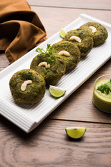 Hara bhara Kabab or Kebab is Indian vegetarian snack recipe served with green mint chutney over moody background. selective focus