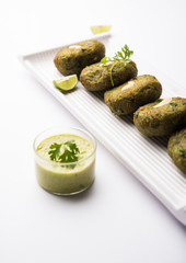 Hara bhara Kabab or Kebab is Indian vegetarian snack recipe served with green mint chutney over moody background. selective focus