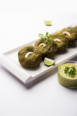 Hara bhara Kabab or Kebab is Indian vegetarian snack recipe served with green mint chutney over moody background. selective focus