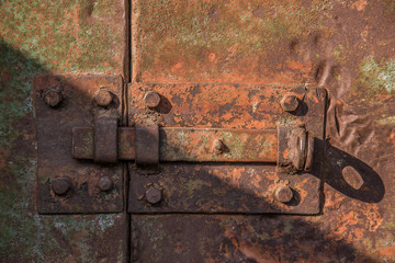 Old rusty metal latch on metal door