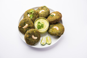 Hara bhara Kabab or Kebab is Indian vegetarian snack recipe served with green mint chutney over moody background. selective focus