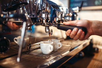 Fototapeta na wymiar Barista hand pours beverage from coffee machine