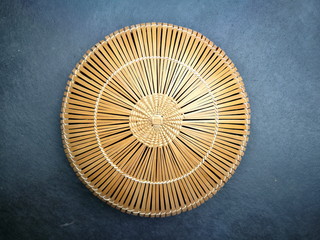 Runde Korbschale aus Bastgeflecht in Beige auf modernem Betonboden in Grau in einer Designerwohnung...