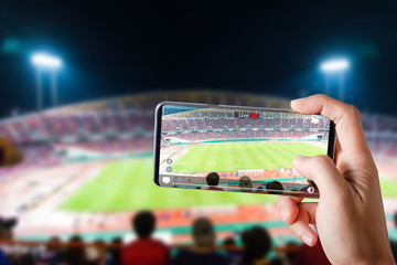 People hands use smartphones record soccer competition match in football stadium live streaming video on internet to social media comment chat to Friend