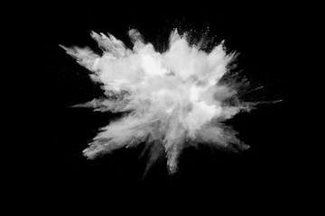 Bizarre forms of white powder explosion cloud against black background.