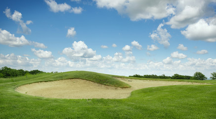 Fototapeta na wymiar Trimmed field and sand bunkers on golf course