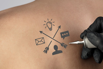 Hand tattooing colorful communication, leadership and creativity concept on naked clear skin