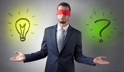 Covered eye businessman with bulb and question sign symbols around