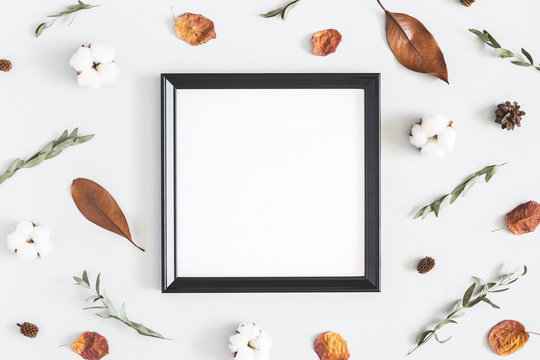 Autumn composition. Photo frame, dried flowers and leaves on white background. Autumn, fall concept. Flat lay, top view, copy space