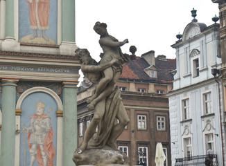 Picture on the wall of Town hall (Ratusz Poznanski) and beautiful sculpture in old town of the city, market square, sunny day, Poznan, Poland