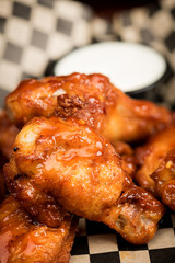 Close up of a chicken wing drum stick with dipping sauce
