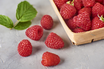 fresh and ripe raspberry in wooden bascet, green leaves