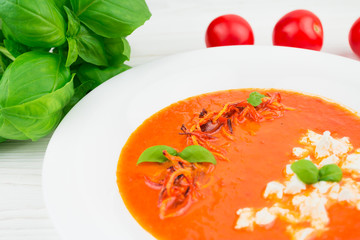 tomato soup on a wooden background, closeup