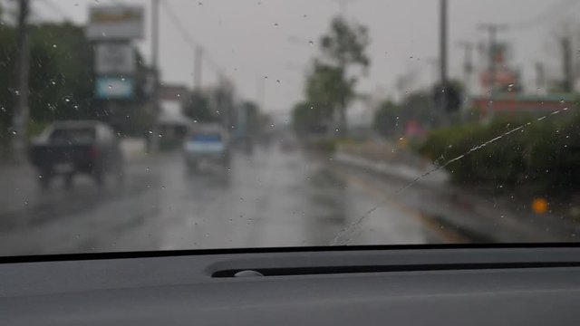 slow motion, wiper clear water on windscreen of car driving in rainy day