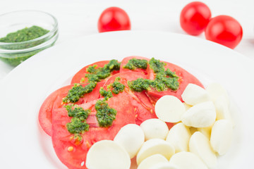 caprese with tomatoes and mozzarella and pesto sauce, close-up