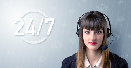 Young female telemarketer with a 24 7 sign next to her