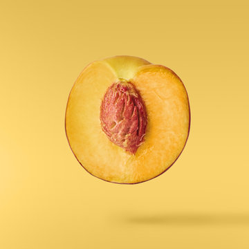 Flying fresh ripe peach with green leaves isolated
