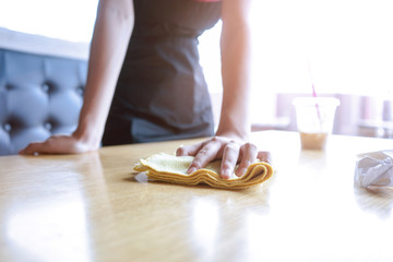 Waitress cleaning the table in coffee shop