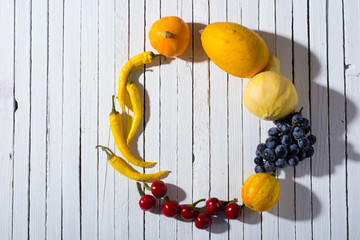 chili peppers, pumpkins and grape on white wood table