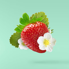 Flying Fresh tasty ripe strawberry with green leaves