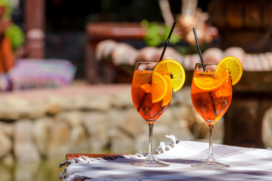 Aperol spritz cocktail glass plaid table leaves sun orange ice bucket shadow sunlight