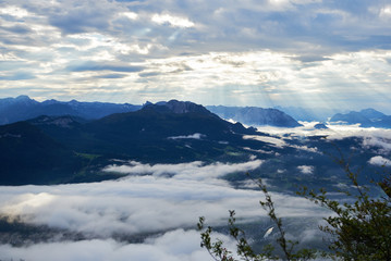 Rays of light shining through the clouds over mountains. Alps, Salzkammergut region, Bad Goisern, Austria